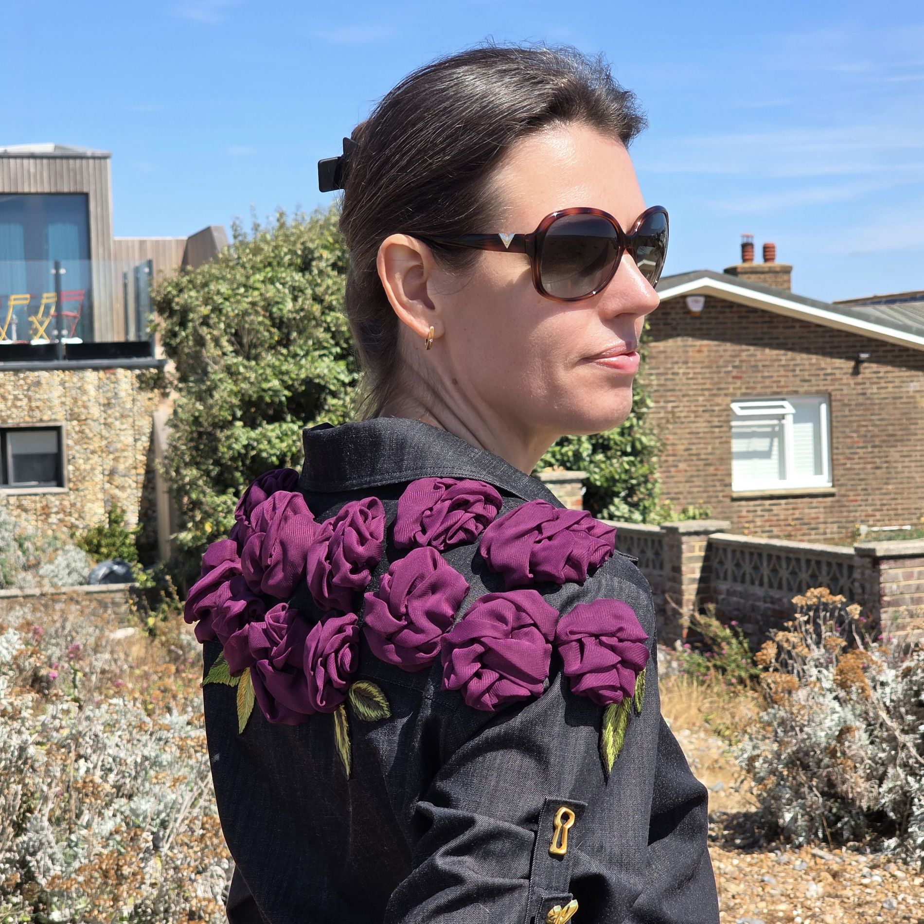 Close-up of the Rose Jumpsuit showing the layered fabric roses, embroidered leaves and their placement around the shoulder.